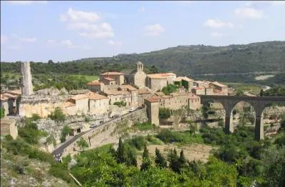 Quel est le nom de ce beau village de l'Hérault tapi sur un promontoire modelé par deux canyons qui fut le théâtre le 22 juillet 1210 du massacre de 180 cathares ?