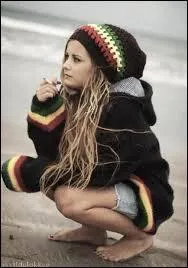 Vêtements amples, colorés, dreadlocks cachés sous un large bonnet de laine :