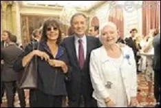 Elle porte un patronyme pouvant être le synonyme de joli. Qui est la femme à la droite de Michel Drucker dont on dit qu'elle est l'ombre ?