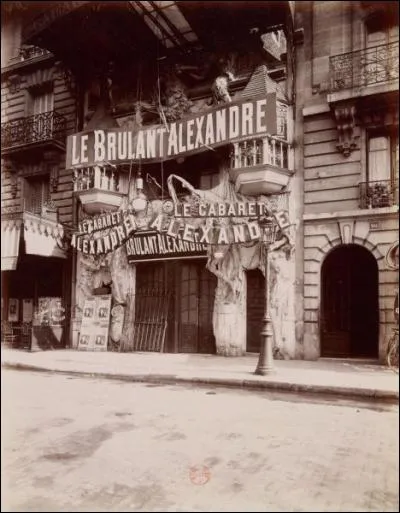 Revenons en arrière juste quelques années auparavant, un cabaret nommé : "Le bruyant Alexandre", du nom de son propriétaire, ouvre . Par qui sera-t-il poursuivi en justice pour concurrence déloyale ? (La décoration sculptée de la façade que l'on voit ici est héritée du cabaret des Truands.)