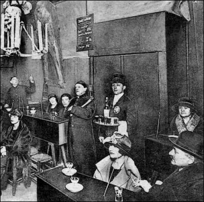 Mais revenons au cabaret où tous ont l'air de s'amuser (surtout les femmes). On voit le maître de cérémonie mais que tient-il dans ses mains alors qu'il se prépare à vous conter des histoires à mourir debout ?