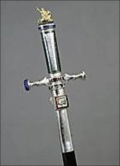 Cette épée très raffinée créée par le sculpteur et orfèvre géorgien Goudgi, représente une croix de Saint André. Sur le pommeau figure un minuscule Saint Georges terrassant le dragon; en bas de l'étui de cuir noir, la Toison d'or. Parmi les autres symboles : Clio, muse de l'histoire, un coq gaulois, un globe terrestre et un scarabée. Mais appartient-elle à un homme ou une femme ?