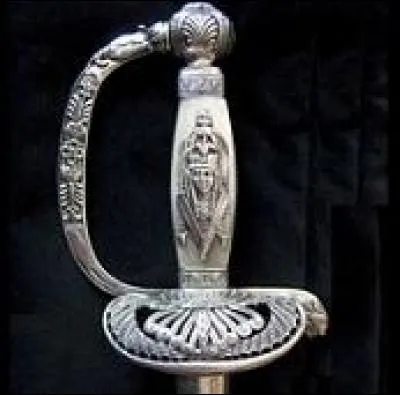 Cette épée ancienne, de membre de l'Institut d'Égypte, ayant appartenu au général Decouz, est faite d'argent doré, nacre, acier et cuir. L'épée, typique exemple de l'égyptomanie, est ornée d'un décor inspiré par l'art égyptien : figure féminine sur la fusée, tête de lion sur le quillon, palmiers, déesse Hathor. À quel historien d'art appartient-elle ?