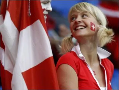 Un sourire pareil, il y a de quoi faire une croix dessus. Quel semble être le pays que cette jeune femme supporte ?