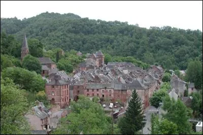 Ce village en grès rouge, dominé par son château, conserve une tour-porche d'entrée de ville. Quel est ce village ?