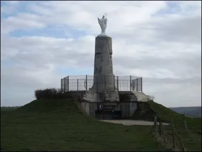 Orientée vers la mer pour protéger les pêcheurs et les marins, placée sur le toit d'un blockhaus, Notre-Dame-de-la-Falaise règne du haut de ses sept mètres. Que représente le piédestal de cette statue qui comprend trois hauts-reliefs sculptés ?