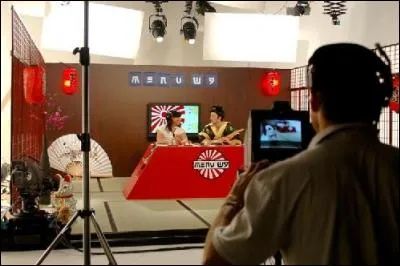 Quels objets défilent sur un tapis roulant devant les présentateurs ?