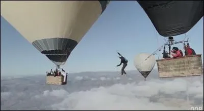 J'observe l'image et je vois : un homme qui tombe du ciel entre deux montgolfières !