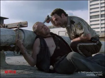 Pourquoi Merle Dixon a-t-il été menotté sur le toit de l'immeuble ?