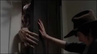 Après que Carl se soit fait attaquer par un rôdeur dans une maison, qu'écrit-il sur la porte ?