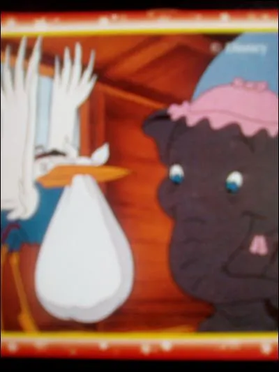 Dans "Dumbo", sur quoi est assise la cigogne pendant qu'elle regarde sa carte ?