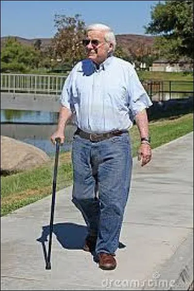 Ce monsieur marche à l'aide d'une canne.
